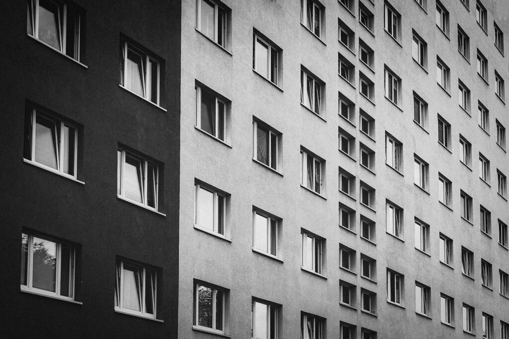 Diese beeindruckende Aufnahme einer Wohnblock-Fensterfront in Chemnitz fängt die Symmetrie und regelmäßige Anordnung der Fenster in einer Weise ein, die die Aufmerksamkeit auf sich zieht. Die zahlreichen Fenster repräsentieren auch die Vielfalt des Lebens und der Geschichten, die sich hinter den Mauern dieses Wohnblocks abspielen. Hinter jedem Fenster verbirgt sich eine eigene Welt, eine eigene Lebensweise und Persönlichkeit. Es lädt den Betrachter ein, einen genaueren Blick auf die Details und die Geschichten zu werfen, die in solch einer scheinbar simplen Ansicht verborgen liegen.
