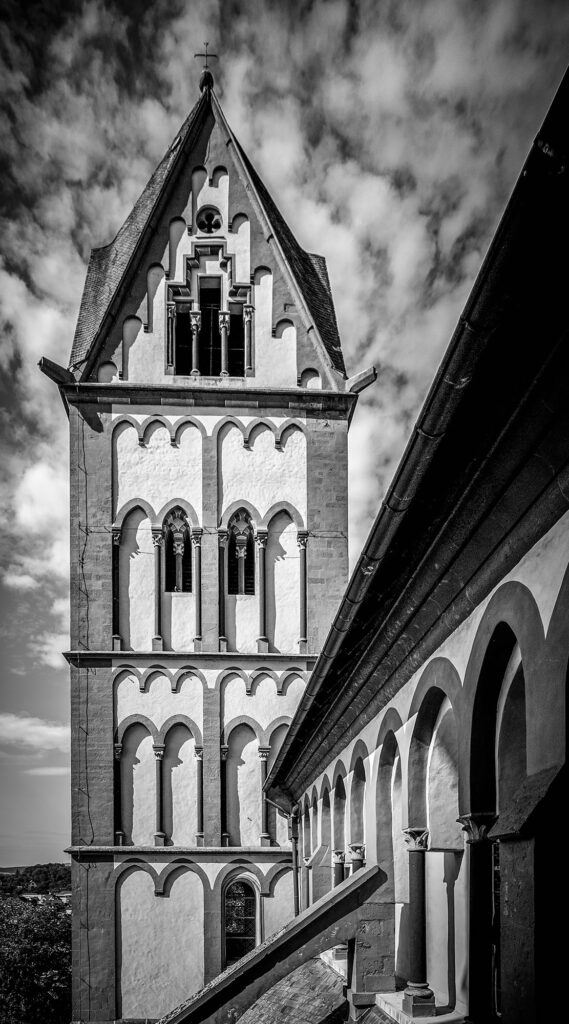 Weit über dem Trubel der Stadt erhebt sich der Turm in den Himmel – kraftvoll, ruhig, fast entrückt. Der Blick auf die romanische Architektur offenbart Klarheit und Struktur, gleichzeitig aber auch ein Gefühl von Zeitlosigkeit. „Stille Höhe“ beschreibt nicht nur den Standort der Kamera, sondern auch die Atmosphäre: ein Moment des Innehaltens über den Dächern, wo Wind, Licht und Geschichte aufeinandertreffen. Ein Bild über das Oben, ohne zu erheben – über die Erhabenheit in der Stille.