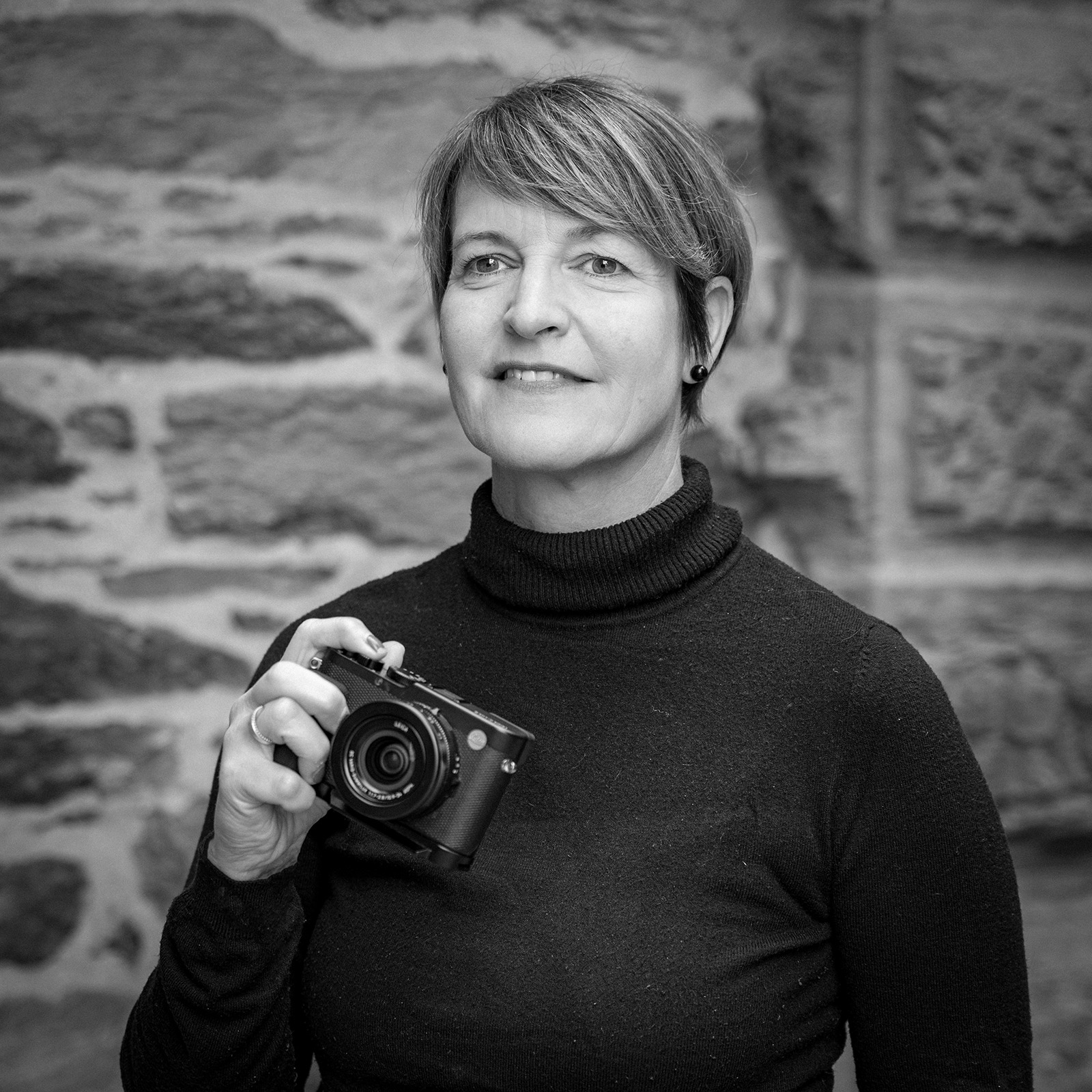 Alexandra Wagner im Porträt mit Kamera, symbolisch für ihren fotografischen Blick