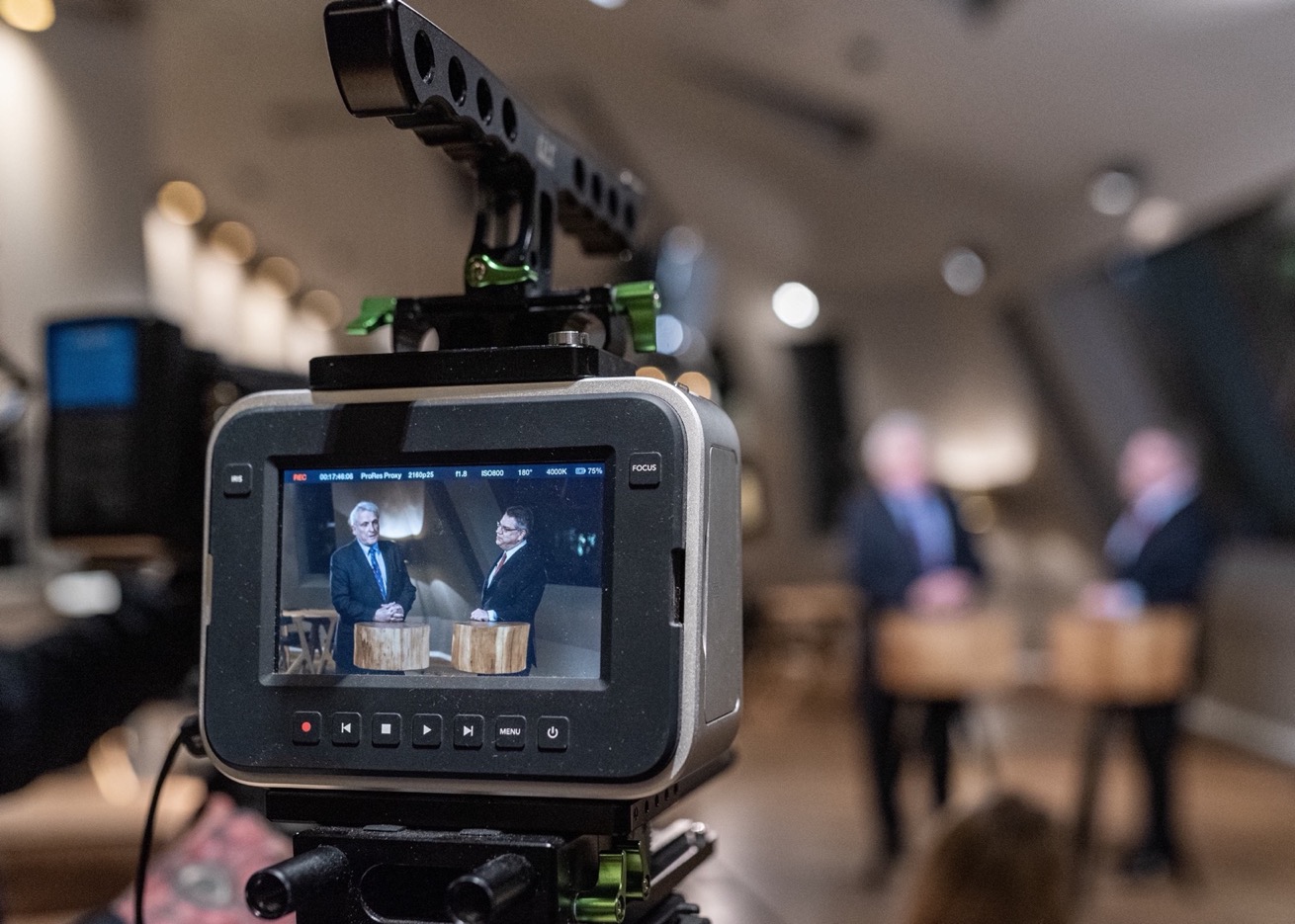 Monitoransicht während einer Videoproduktion – zwei Personen im Interview vor unscharfem Hintergrund.