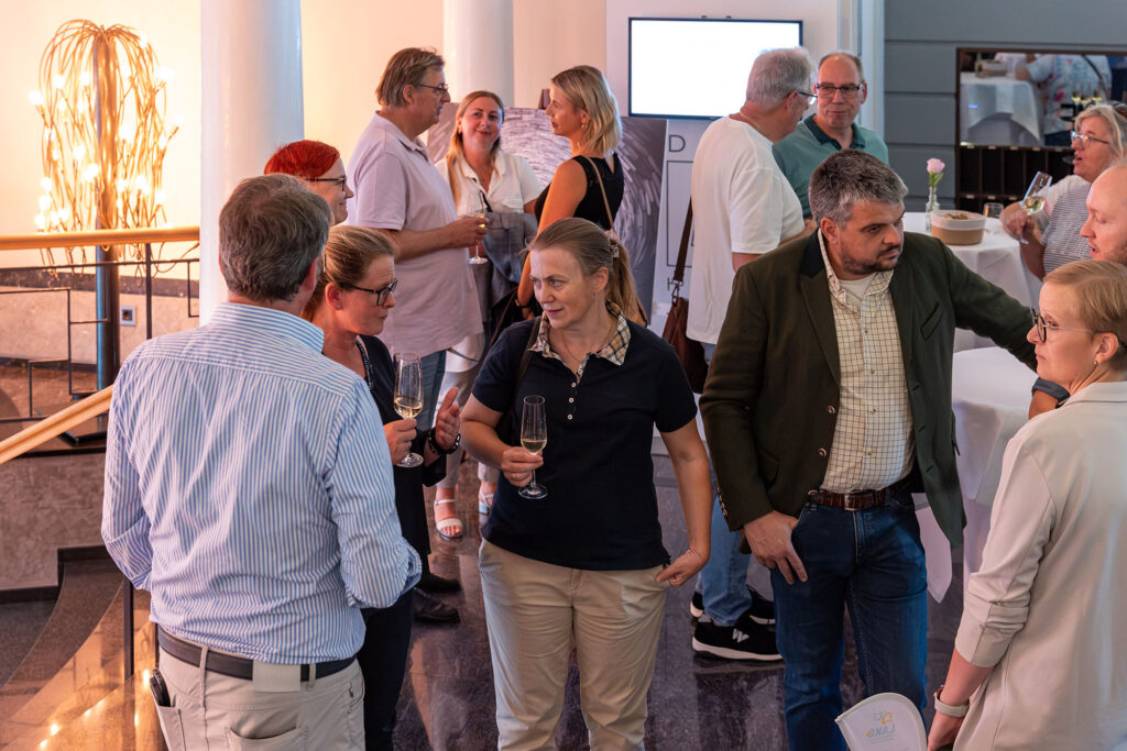 Mehrere Gäste unterhalten sich während der Vernissage im Dom Hotel Limburg.