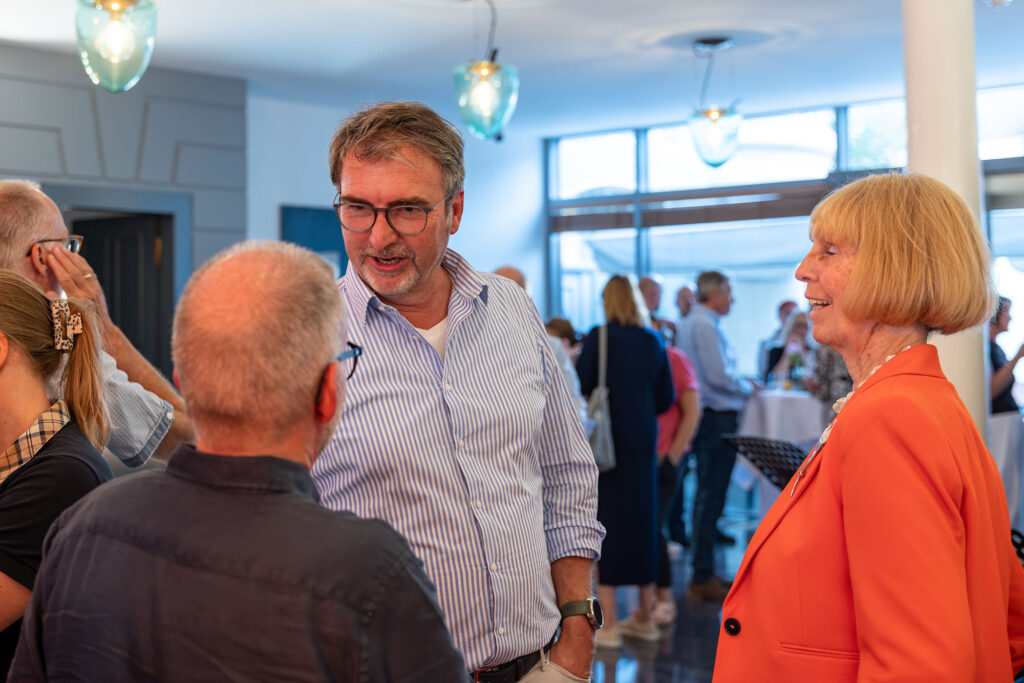 Mehrere Gäste unterhalten sich während der Vernissage im Dom Hotel Limburg.