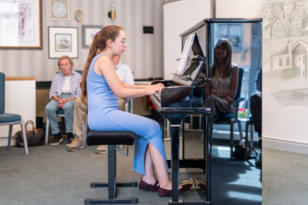 Junge Pianistin spielt bei der Finissage einer Foto- und Schmuckausstellung im Dom Hotel Limburg am Klavier.