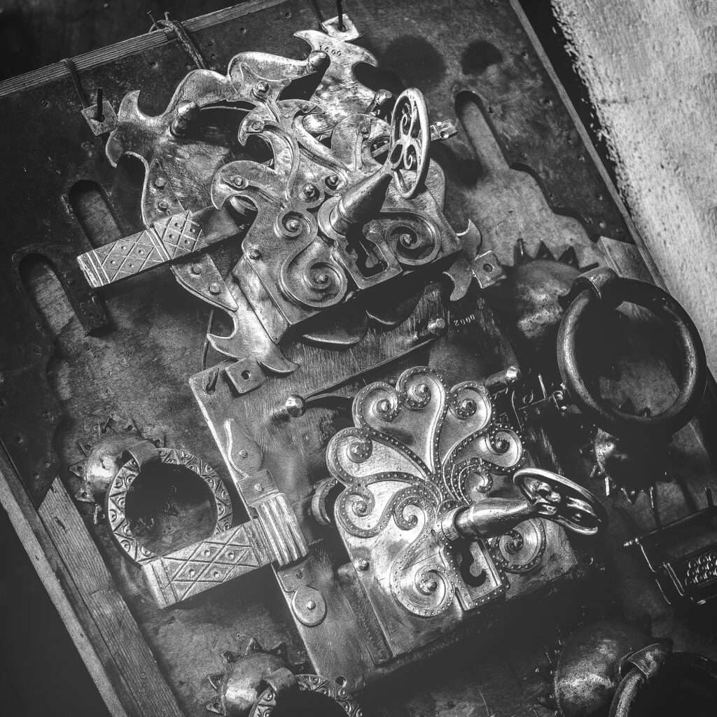 Schwarzweißfotografie eines kunstvoll verzierten Metallornaments in Nahaufnahme