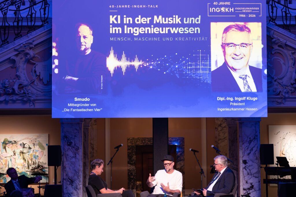 Bühne mit Leinwand zum Talk KI in der Musik und im Ingenieurwesen