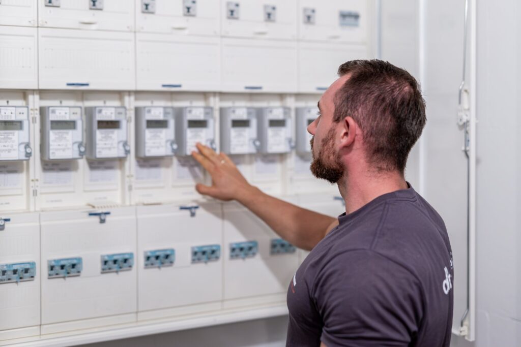 Mitarbeiter der Dienstleistungen Albert Weil GmbH liest Stromzähler im Technikraum ab