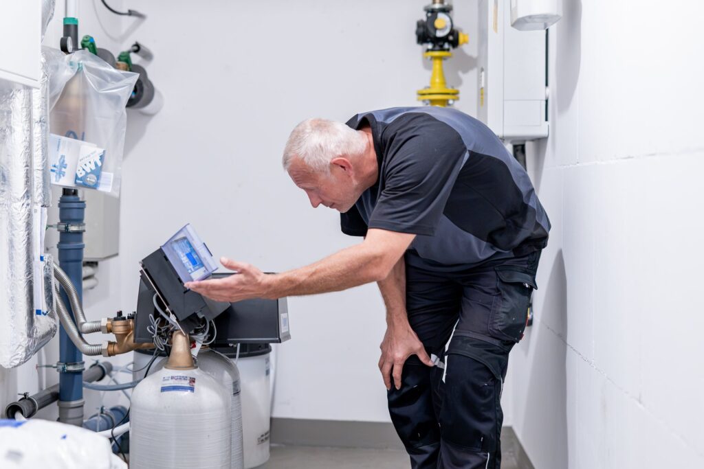 Mitarbeiter prüft die Steuerung der Wasseraufbereitungsanlage im Technikraum