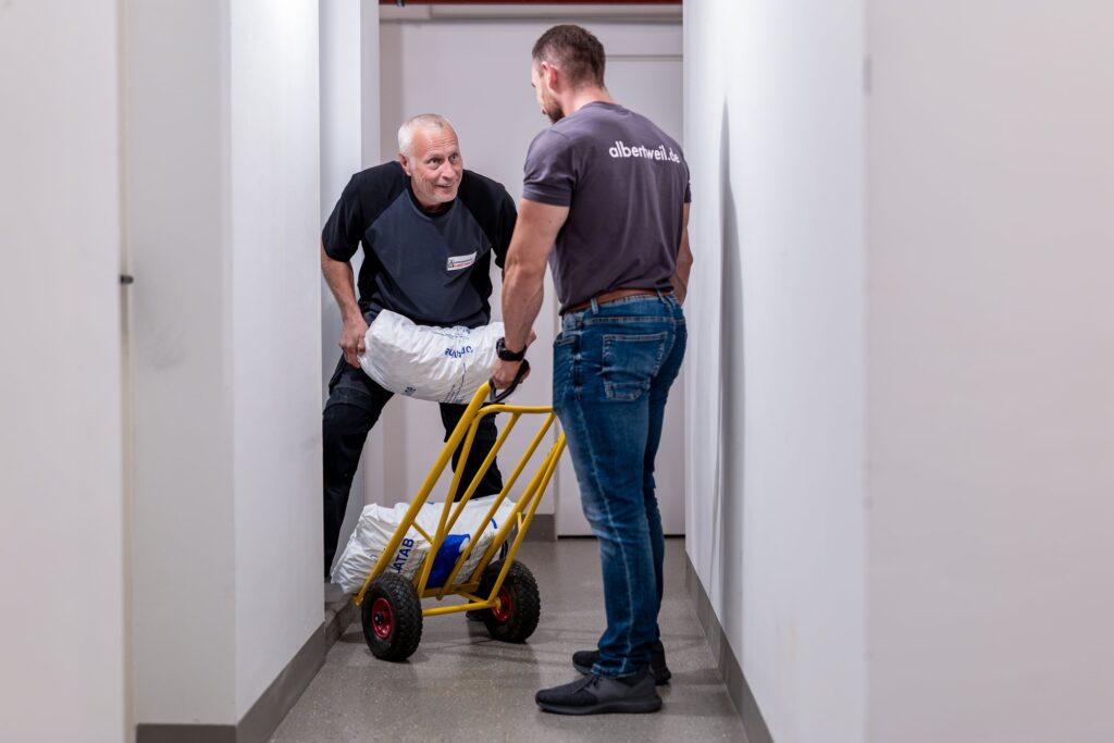 Salzsack für die Enthärtungsanlage wird auf der Sackkarre durch den Flur gebracht