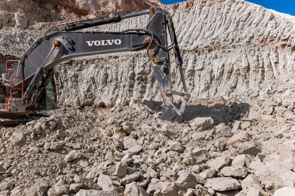Bagger vor der hellen Tonwand in der Grube Meudt