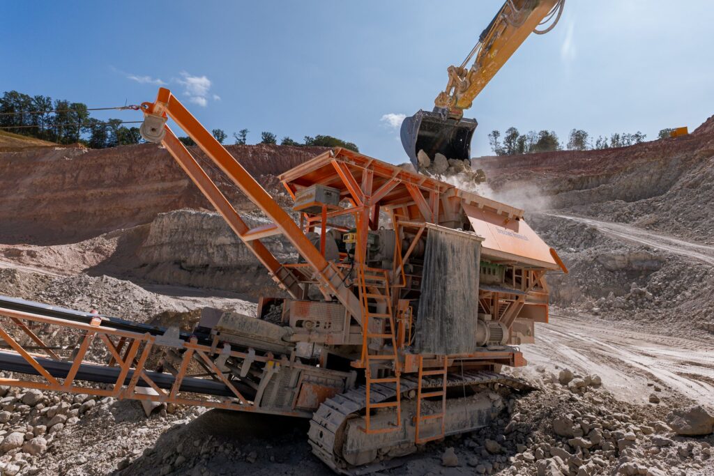 Bagger befüllt den mobilen Brecher
