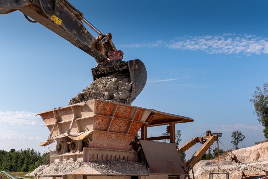 Bagger befüllt den Brecher mit Ton